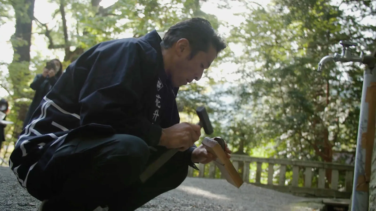 神社の境内で鑿を打つ宮大工